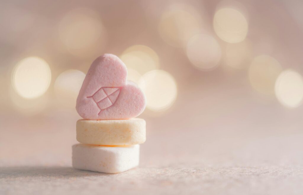 Close-up of heart-shaped candy with a warm bokeh background, perfect for holiday themes.